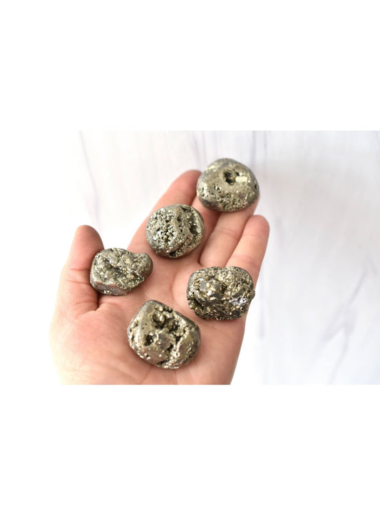 Les cristaux de pyrite d'or d'apothicaire à coeur ouvert ont dégringolé des pierres pour la manifestation